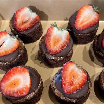 Strawberry halves on top of chocolate brownie bites.
